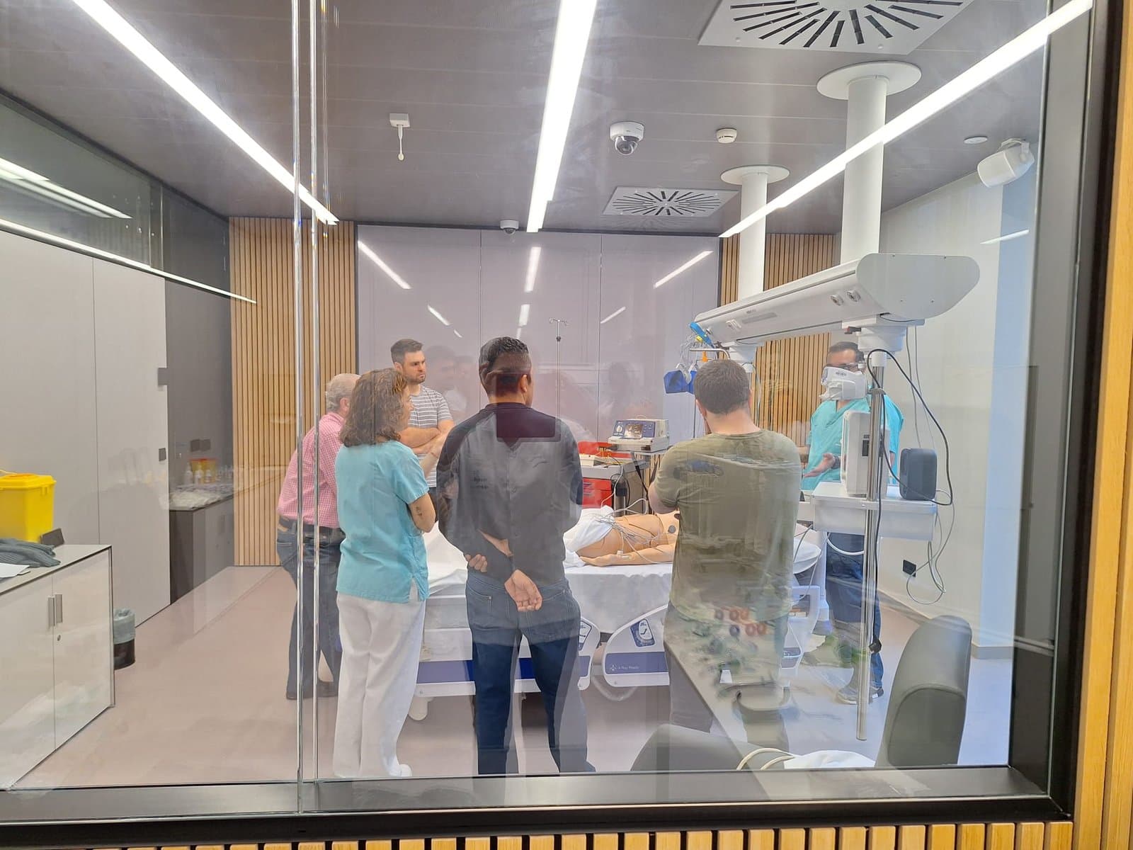 Sala de simulación clínica de alta fidelidad vista desde la sala de control